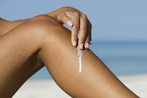 Person applying Green People Suncream to their leg for sun protection